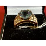 Hallmarked Jewellery: 9ct. Gold ring set with a round blue topaz with cubic zirconian set shoulders.