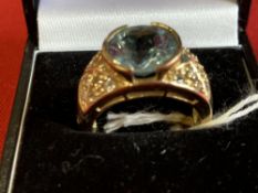 Hallmarked Jewellery: 9ct. Gold ring set with a round blue topaz with cubic zirconian set shoulders.