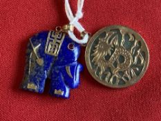 Jewellery: Yellow metal pendants, one in the form of a lapis lazuli elephant, the other circular