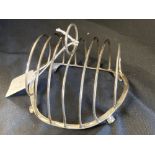 White Metal: Oval wire toast rack, tests as silver, stood on four feet NB: One engraved with th Hood