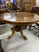 Victorian rosewood tilt top oval dining table on a baluster pedestal and four scrolled feet. 56¾in.