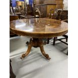 Victorian rosewood tilt top oval dining table on a baluster pedestal and four scrolled feet. 56¾in.