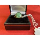 Jewellery: Yellow metal ring set with an oval Jade centre, with a rose cut diamond either side,