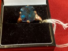 Jewellery: Yellow metal ring set with a rectangular cut blue topaz, tets as 9ct. gold. Weight 4·7g.