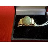 Jewellery: Yellow metal ring set with a round cabochon cut jade, tests as 14ct. gold. Weight 3·5g.