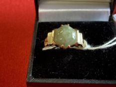 Jewellery: Yellow metal ring set with a round cabochon cut jade, tests as 14ct. gold. Weight 3·5g.