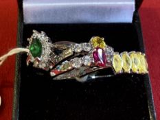 Jewellery: White metal rings. All four set with coloured and white synthetic stones. All tests as