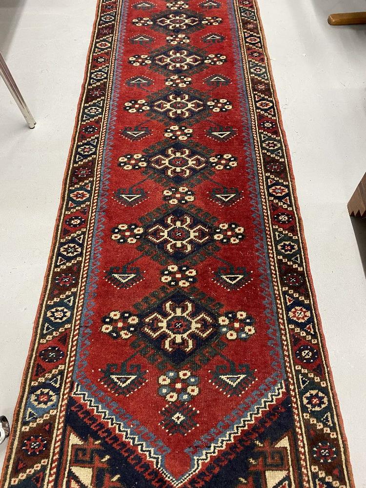 Carpets & Rugs: 19th cent. Kazak style runner with red ground and nine large guls with geometric