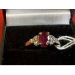 Jewellery: White metal ring, set with an oval cut ruby, estimated weight of 1·00ct. with three