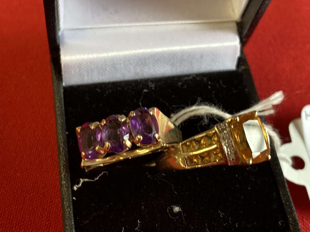 Jewellery: Two yellow metal rings, one set with three oval amethysts, and one with a citrine