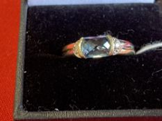 Jewellery: Yellow and white metal ring set with a blue topaz and two 8 cut diamonds, tests as 9ct.