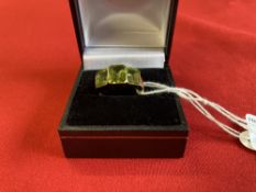 Jewellery: Yellow metal ring set with three rectangular cut peridot, tests as 9ct. gold. Weight 4g.