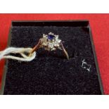 Hallmarked Jewellery: 18ct. Gold floral cluster circle set with a round sapphire, estimated weight