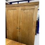 Rustic stripped pine wardrobe with single drawer beneath.