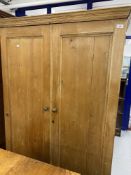 Rustic stripped pine wardrobe with single drawer beneath.