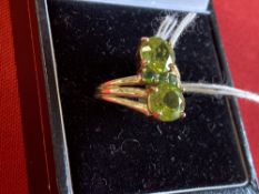 Hallmarked Jewellery: 9ct. Gold ring set with two large and three small peridot. Hallmarked