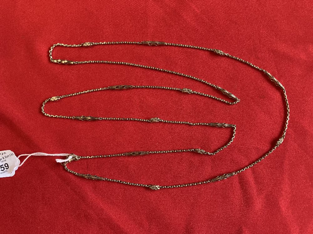 Victorian yellow metal long guard chain, trace links with pierced sections. Length 57½ins. Tests