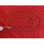 Victorian yellow metal long guard chain, trace links with pierced sections. Length 57½ins. Tests