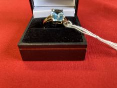 Jewellery: Yellow metal ring set with a rectangular cut blue topaz, estimated weight 2·25ct. with