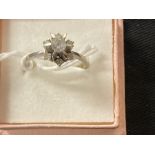 Jewellery: White metal ring cluster set with seven synthetic white spinel, tests as 18ct. white