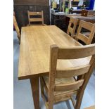 Good quality solid oak modern extending dining table with a set of matching four ladder back