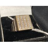 Jewellery: Yellow metal ring with a square top body with twenty four brilliant cut diamonds,