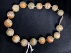 Jewellery: Jade circular beads (17) brown/green 20mm to 15mm. Length 14ins.