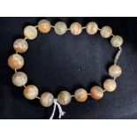 Jewellery: Jade circular beads (17) brown/green 20mm to 15mm. Length 14ins.