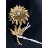 Jewellery: Yellow metal flower brooch set with seven brilliant cut diamonds, estimated weight of (7)