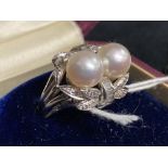 Jewellery: White metal ring cluster with two 8mm cultured pearls and ten baguette cut diamonds,