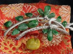 Jewellery: White metal spray brooch set with fourteen leaf shaped jade. Tests as 14ct white gold.