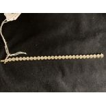 Jewellery: Yellow metal bracelet with disc links, each set with a single diamond, twenty eight in