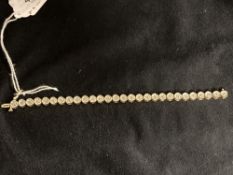 Jewellery: Yellow metal bracelet with disc links, each set with a single diamond, twenty eight in