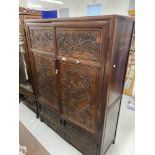 20th cent. Chinese hardwood compound cabinet carved with high relief stylised Chinese scenes. 47½