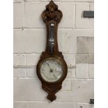 20th cent. Oak aneroid barometer with carved decoration. The mercury temperature gauge has been