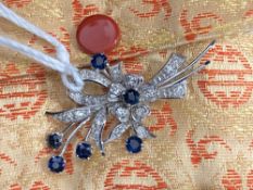 Jewellery: White metal floral spray brooch set with six round cut sapphires, estimated weight of (6)