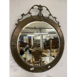 19th cent. Circular bevelled mirror with pressed brass frame surmounted by ribbon swags with tin
