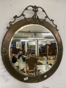 19th cent. Circular bevelled mirror with pressed brass frame surmounted by ribbon swags with tin
