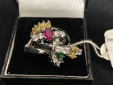 Costume Jewellery: White metal rings. All four set with coloured and white synthetic stones. Total