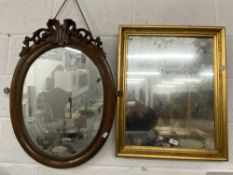 Mirrors: 19th cent. Oval in mahogany frame surmounted by scroll carving, 28½ins. x 21ins. Plus a