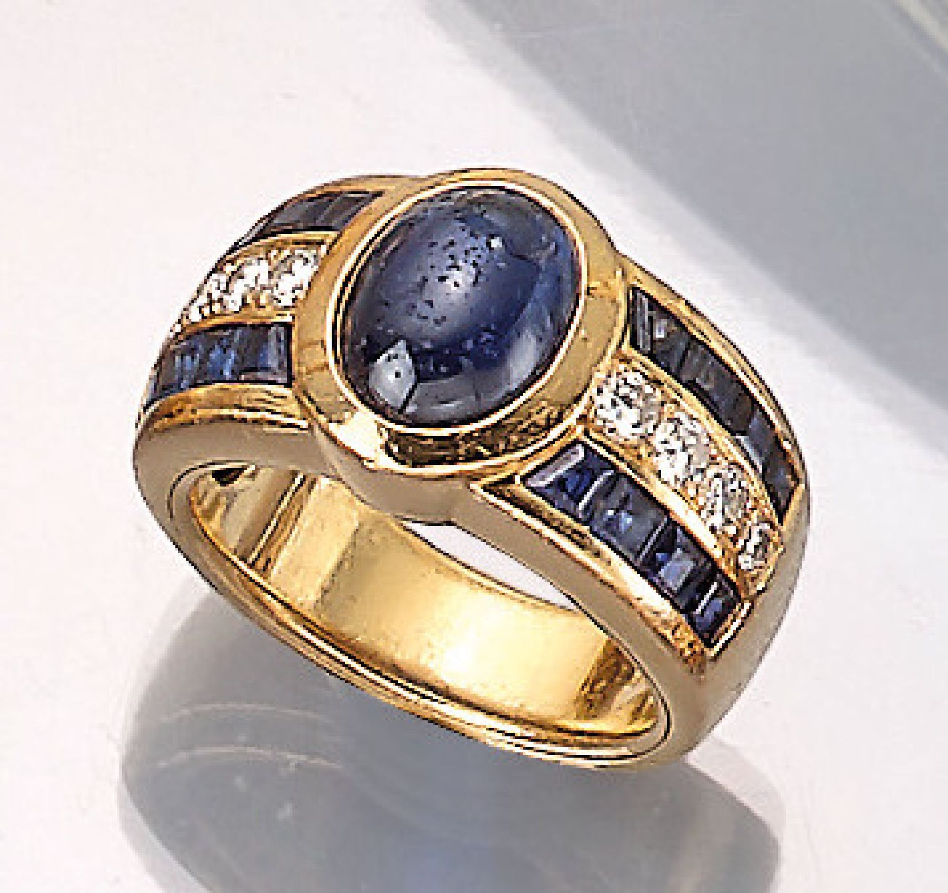 18 kt gold ring with sapphires and brilliants , YG 750/000, centered oval sapphirecabochonapprox.