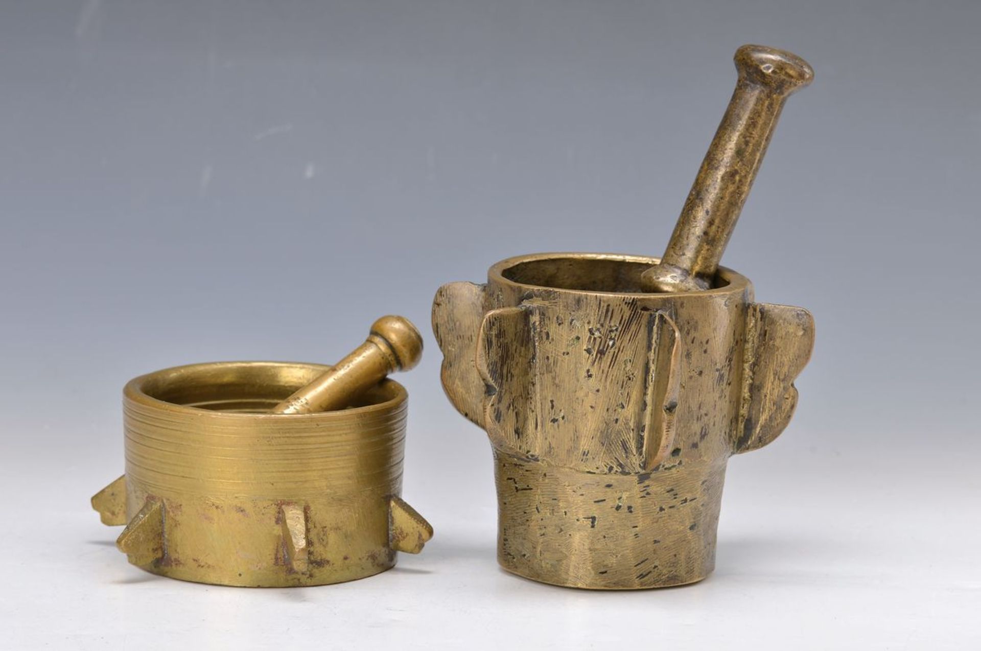2 Mortars with pestles, Spain, 19th c., massive brass cast, one pestle damaged, H. approx. 7