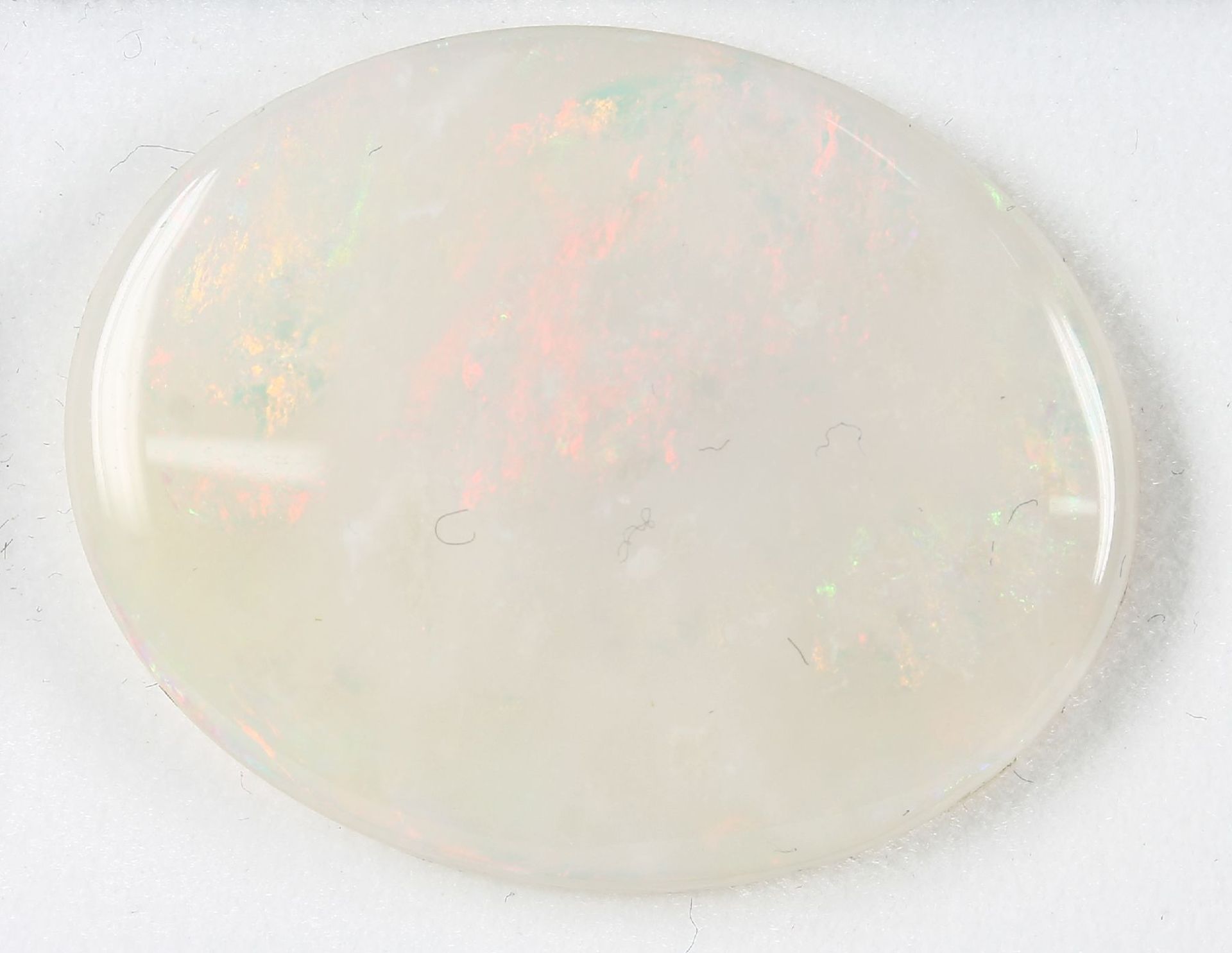 Loose opal disc , 36.94 ct, with nice play of colours, in red and yellow, approx. 35.10 x28.04 x 5.