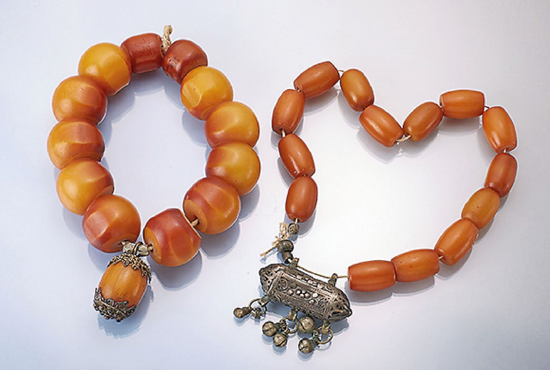 Lot 2 amber chain, Tibet with silver- pectorale , approx. 1900, big olives respectively rondels,