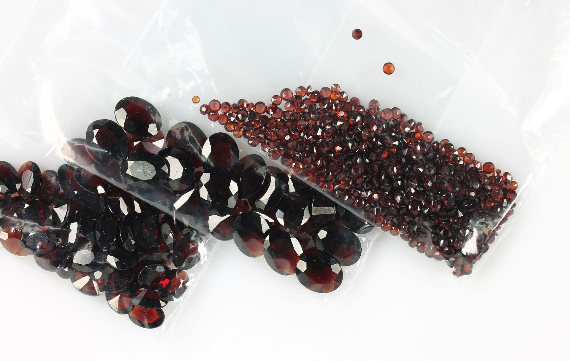 Lot loose bevelled garnets , total 106.16 ct, oval- and round bevelled Valuation Price: 3200, -