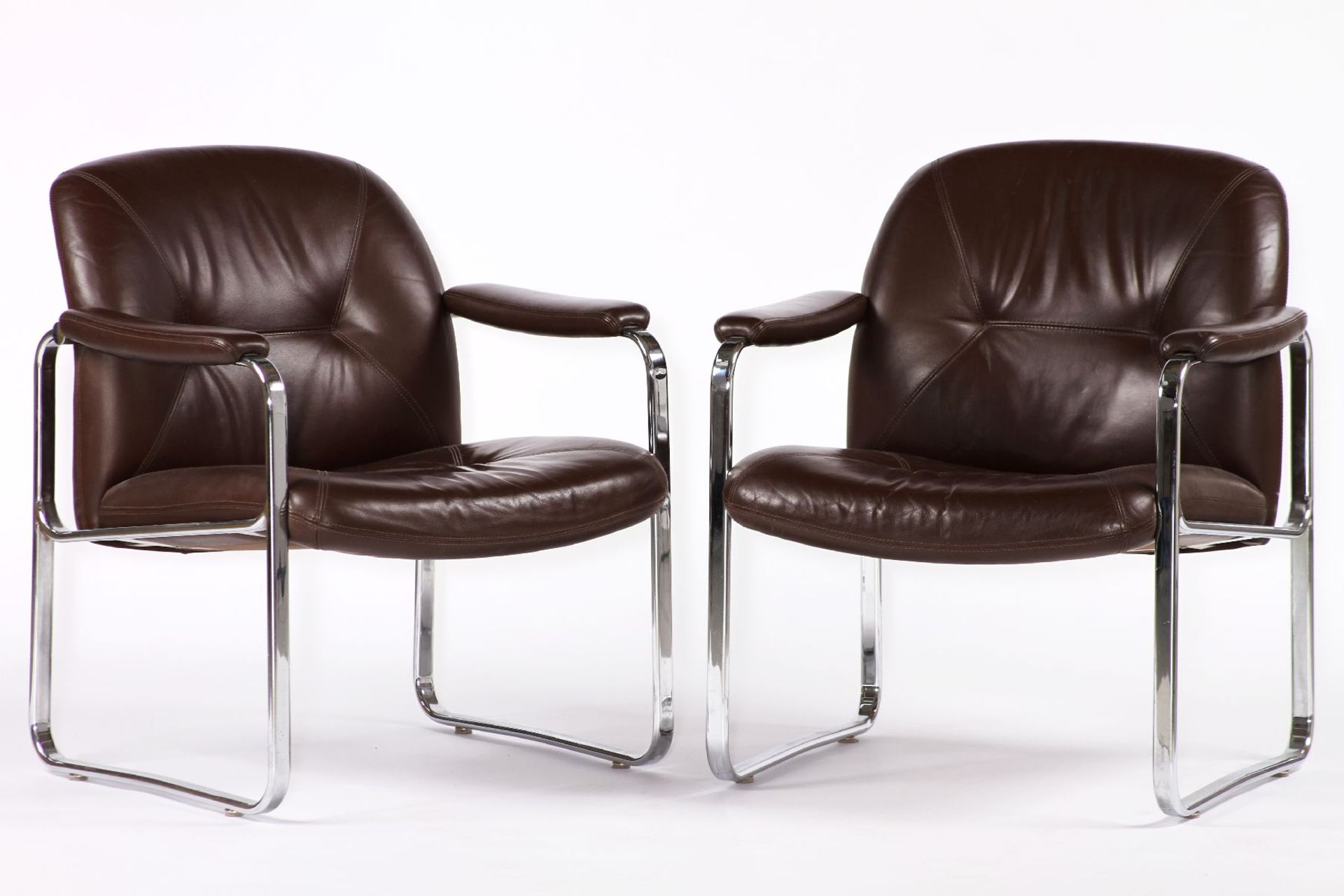 2 armchairs, chromed metal frame, screwed-on seat and armrests with brown leather covers, high-