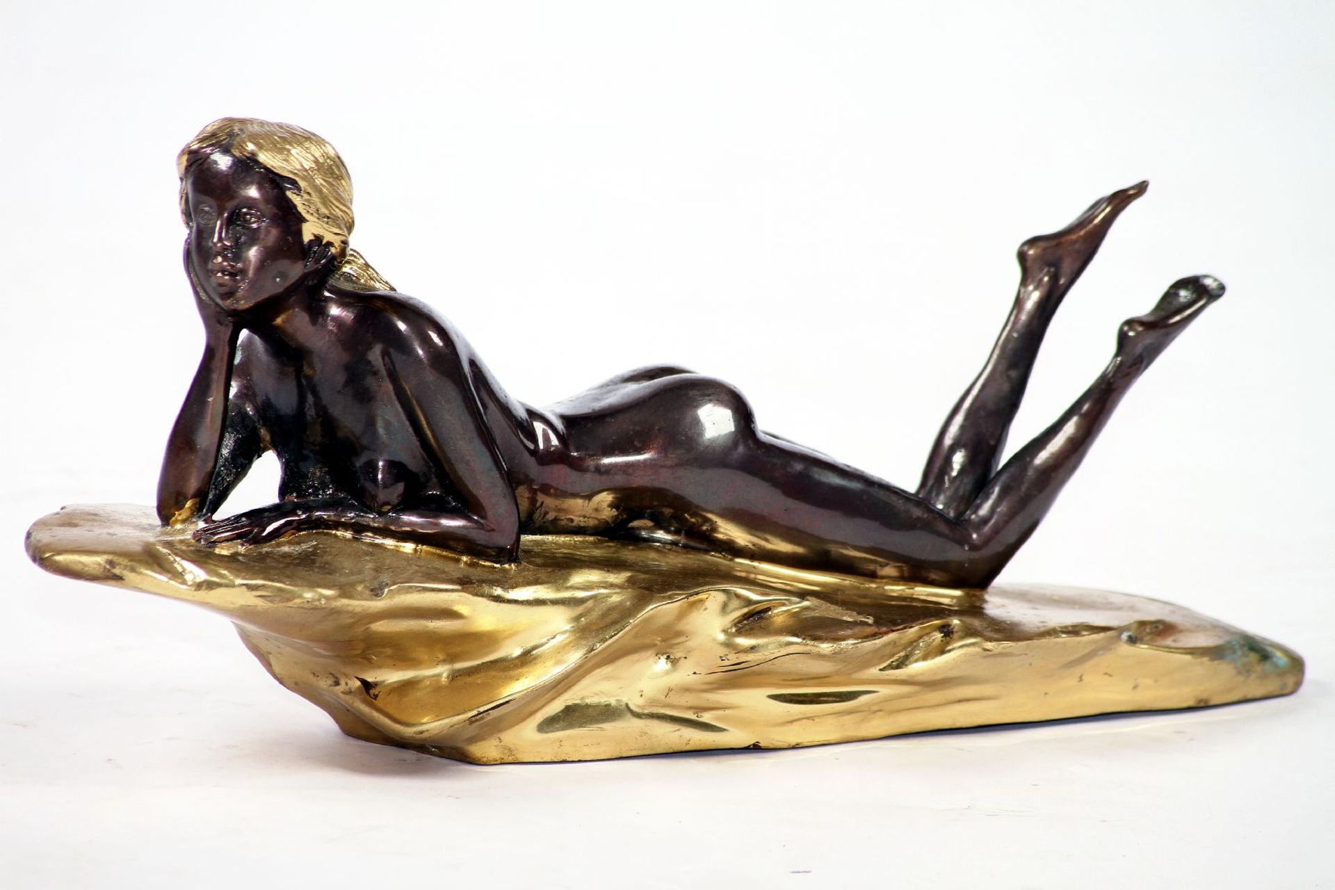 Lying nude female, bronze, brown and dark brown patinated, indicated rock and hair polished