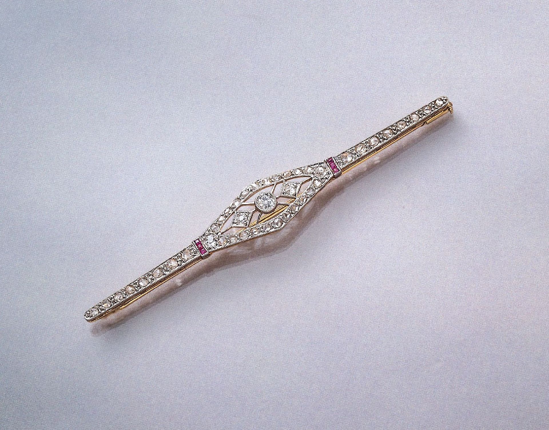 18 kt Gold Art-Deco-Brosche mit Diamanten und Rubinen, GG/WG 750/000, 6 facett. Rubin Karrees zus.