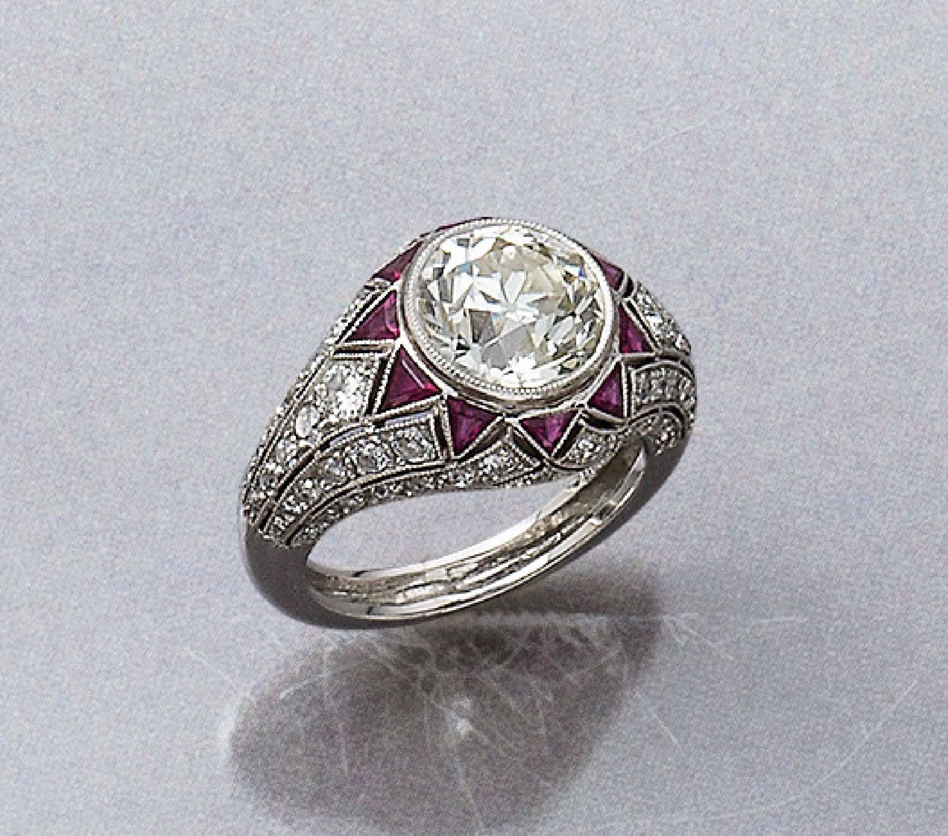 Platin Art-Deco-Ring mit Diamanten und Rubinen, um 1920, mittig Altschliff- Diamant ca. 3.10 ct l.