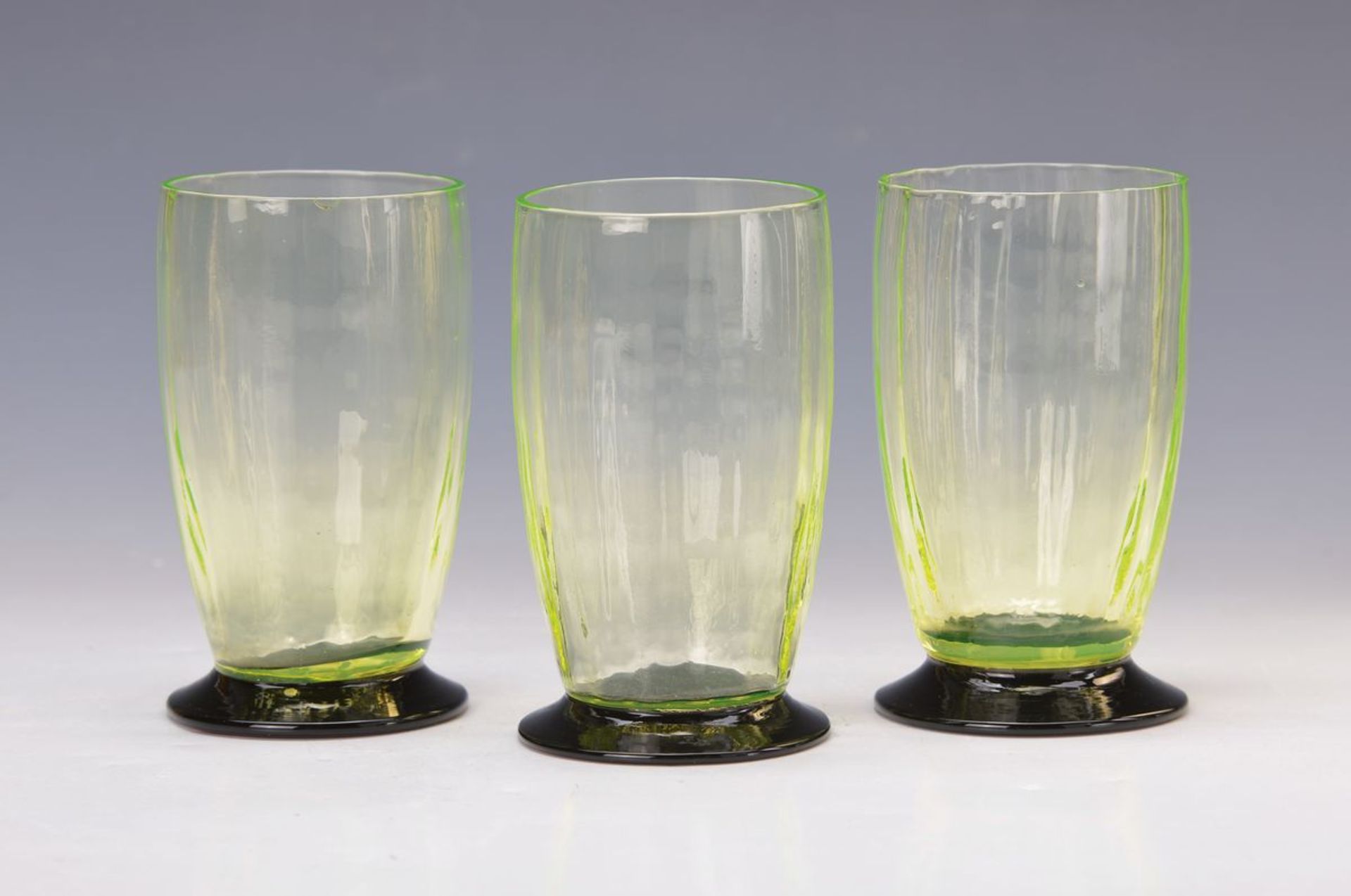 3 Urangläser, deutsch, 30er Jahre, optisch geblasenes Glas, dunkler Fuß, H. ca. 12 cm ein Glas